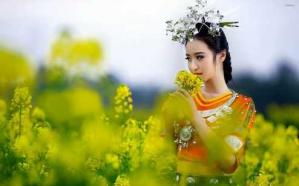 Beautiful geisha smelling the flower